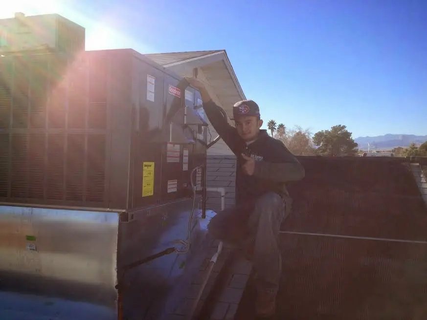HVAC technician performing Air Duct Repair on a rooftop unit in Lloyd